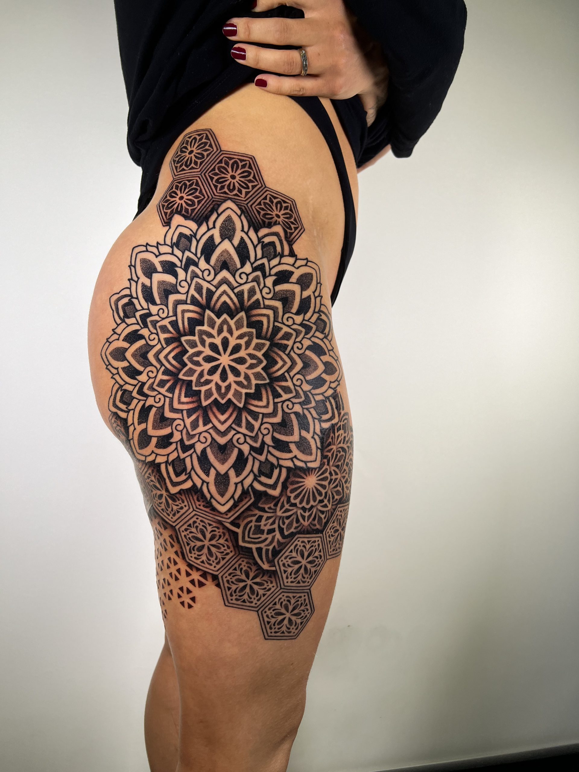 A female tattoo artist sits at a reception desk preparing for a walk-in tattoo