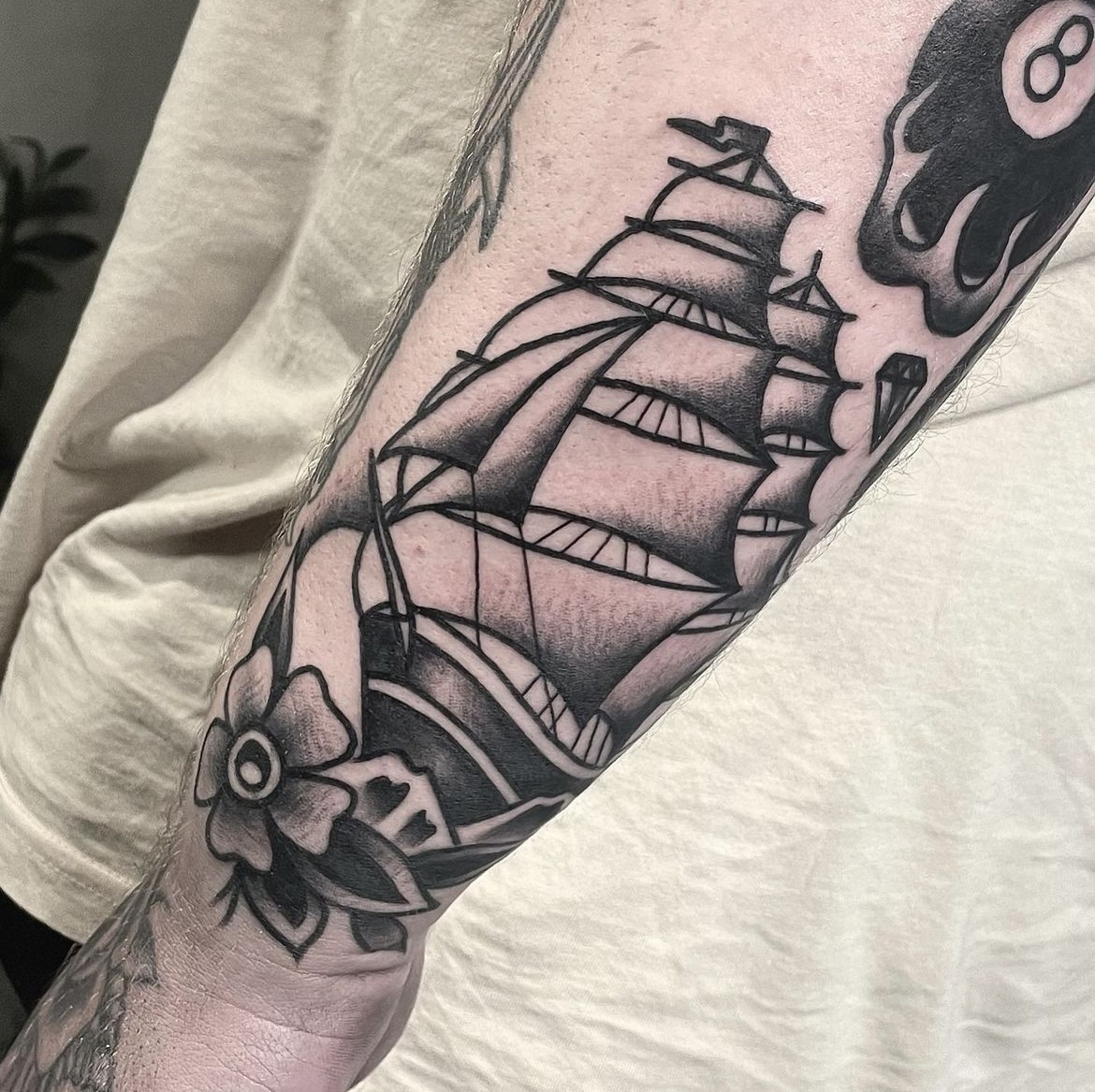 traditional-tattoo-matt5 Image of a new tattoo on a mans arm. The style of the tattoo blends realism style with an artistic flair. It is black and grey and also red colour.